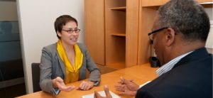 Photograph of a woman and man having a conversation in an office