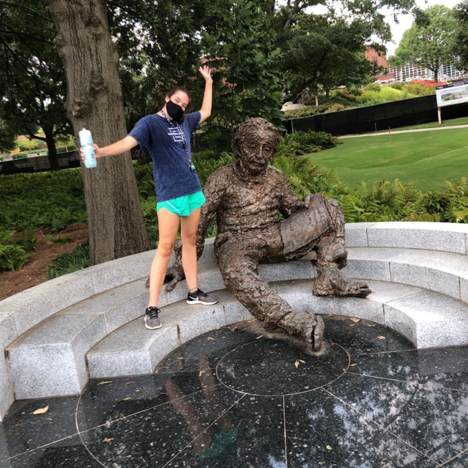 Student posing next to statue of Einstein.